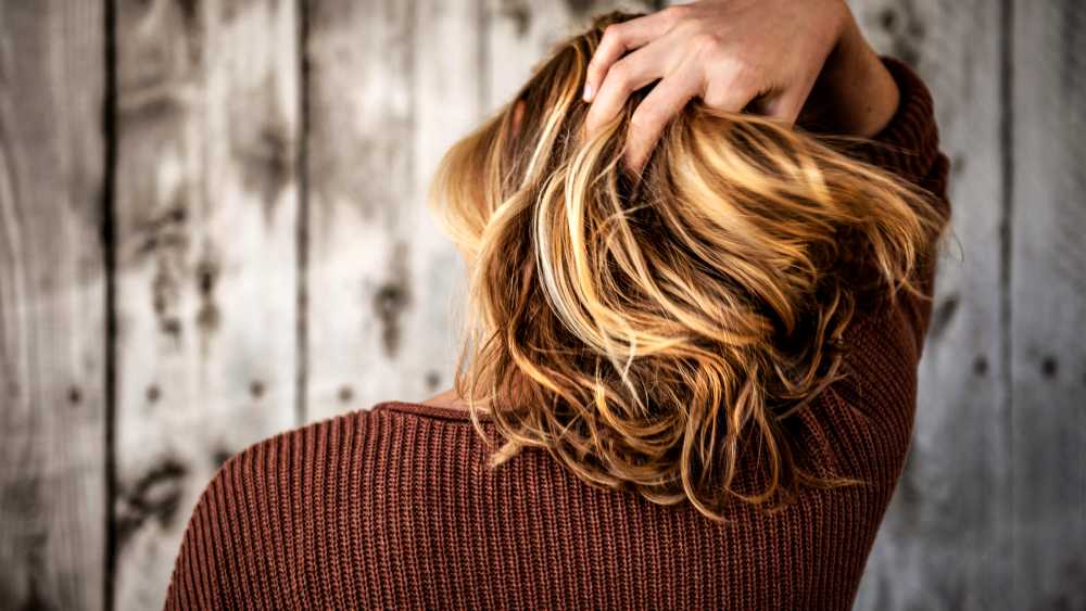 client facing away from the camera as they run their fingers through their hair